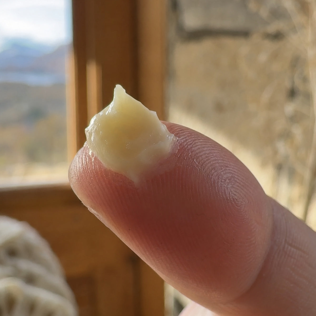 Textura mantecosa del bálsamo en la yema del dedo